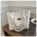 Detalle de bolso tote de felpa blanca con asas de cuero sobre superficie de madera - Blanco