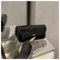 Detalle de bolso bandolera de charol negro con cadena dorada y hebilla metálica rectangular - Negro