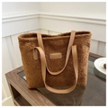 Detalle de bolso tote marrón de peluche con textura suave y etiqueta de moda en cuero - Marrón