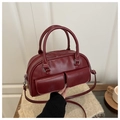 Vista dettagliata della borsa Boston bordeaux con texture in pelle e finiture argento - Rosso
