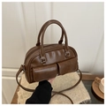 Dettaglio di una borsa Boston vintage marrone con doppie tasche e finitura in pelle lucida - Marrone