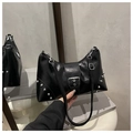 Close-up of black glossy shoulder bag featuring silver rivets and metal buckle detail - Black