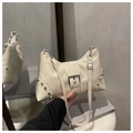 Close-up of cream textured faux leather bag with silver rivets and metal buckle detail - Off White