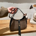 Detail einer braunen Wildleder-Baguette-Tasche mit schwarzem Leder und Goldverschluss - Braun
