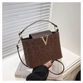 Detail of leopard print handbag with gold V-shaped hardware and brown leather strap - Brown