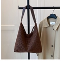 Detalle de bolso hobo de leopardo moderno con correa ancha en un soporte elegante - Marrón