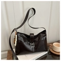 Detailansicht einer Vintage-Schultertasche in Dunkelbraun mit Perlenanhänger und Klappe - Kaffee mit Anhänger