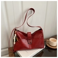 Nahaufnahme einer roten Retro-Lederschultertasche mit silberner Schnalle und Perlenanhänger - Burgunderrot Mit Anhänger