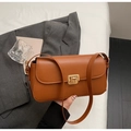 Dettaglio borsa a tracolla vintage in pelle color caramello con chiusura girevole dorata - Marrone