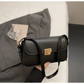 Dettaglio di borsa a tracolla minimalista in pelle nera con fibbia in metallo dorato - Nero