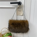 Brown fluffy faux fur pillow bag with silver chain strap hanging on a door handle - Brown