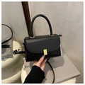 Détail d'un sac bandoulière en cuir noir minimaliste avec un fermoir doré métallique - Noir