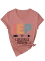 Detail of V-neck dusty rose t-shirt featuring artistic IEP text and knot hem detail - Rose Gold (Black Print)