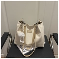 Detail van de gebroken witte leren shopper met een pluche bedeltje en zilveren ketting - Khaki Met Hanger