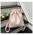 Detail of light pink drawstring backpack with wide straps and waterproof nylon texture - Pink