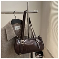 Detailansicht der glänzenden dunkelbraunen Lackleder-Schultertasche mit Gold-Schnallen - Dunkelbraun