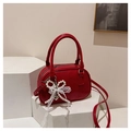 Detail view of red faux leather baguette bag with pearl bow and lace accents - With Pendant Style / Red