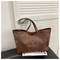 Brown faux leather tote bag with round cutout logo and slim handles for daily commute - Brown