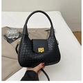 Détail d'un sac à main noir tressé avec fermoir doré et texture en cuir - Noir