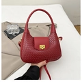 Détail du sac à main tressé bordeaux avec fermoir doré et texture élégante raffinée - Rouge