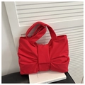 Dettaglio della borsa tote in tela rossa con grande fiocco decorativo e manici larghi - Rosso
