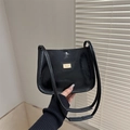 Bolso bandolera trapezoidal negro minimalista con logo dorado y tirantes dobles finos - Negro