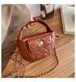 Close-up of brown quilted crescent bag with gold floral buckle and chain strap - Brown