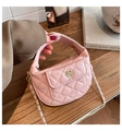 Detailed macro view of a pink quilted mini crescent bag with flower metal clasp - Light Pink