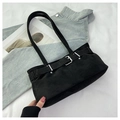 Detail of minimalist black suede shoulder bag with silver buckle on fabric background - Black
