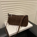 Nahaufnahme der Schultertasche mit Leopardenmuster und Silberbeschlägen vor Studiohintergrund - Braun