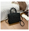 Detail of black glossy handbag with gothic cross embroidery and golden hardware accents - Black