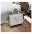 Close-up of beige PU leather handbag featuring intricate white crown embroidery and gold hardware - White