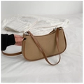 Detailansicht einer Vintage-Schultertasche aus braunem Canvas mit Lederbesatz auf Stoff - Khaki