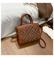 Detailed embroidery and cross-woven texture on a brown leather handbag with gold hardware - Brown