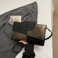 Sac à main chic en cuir noir et serpent avec poignées anneaux argentés sur fond blanc - Marron