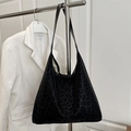 Bolso tote grande con estampado de leopardo y correas negras colgado de un rack - Negro