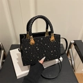 Elegante borsa a mano nera con borchie a stella dorate e manici in pelle intrecciata - Nero