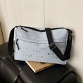 Light blue crossbody bag featuring black and silver star prints and adjustable strap - Blue