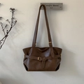Close-up of retro dark brown bucket bag with matte leather finish and belt strap detail - Brown