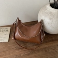 Borsa hobo in pelle marrone con scritta fashion e catena su tavolo in legno vintage - Grande / Marrone
