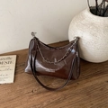 Borsa a secchiello marrone scuro con catena argento e tracolla su tavolo in legno - Grande / Marrone