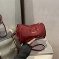 Sac cylindrique en cuir verni rouge brillant avec lettrage doré et bandoulière - Finition brillante / Rouge