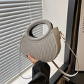 Detail of silver crescent handbag with vertical textures and gold shoulder strap hook - Silver