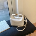 Dettaglio di una mini borsa squadrata bianca testurizzata con fibbia dorata e manico - Bianco