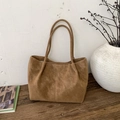 Bolso tote marrón vintage de ante con costuras dobles sobre mesa de madera rústica - Marrón
