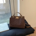 Detail of leopard print handbag with golden square lock and leather handle on vintage books - Brown