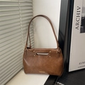 Macro detail of brown vintage leather shoulder bag with gold studs and cutout handle - Brown