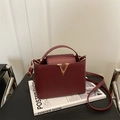 Elegant burgundy crossbody bag with lychee texture and golden V-shaped metal buckle - Red