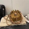 Caramel suede bucket bag featuring a thick braided handle and crossbody strap - Brown