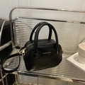 Bolso de mano minimalista en cuero sintético negro con detalles dorados y correa - Negro